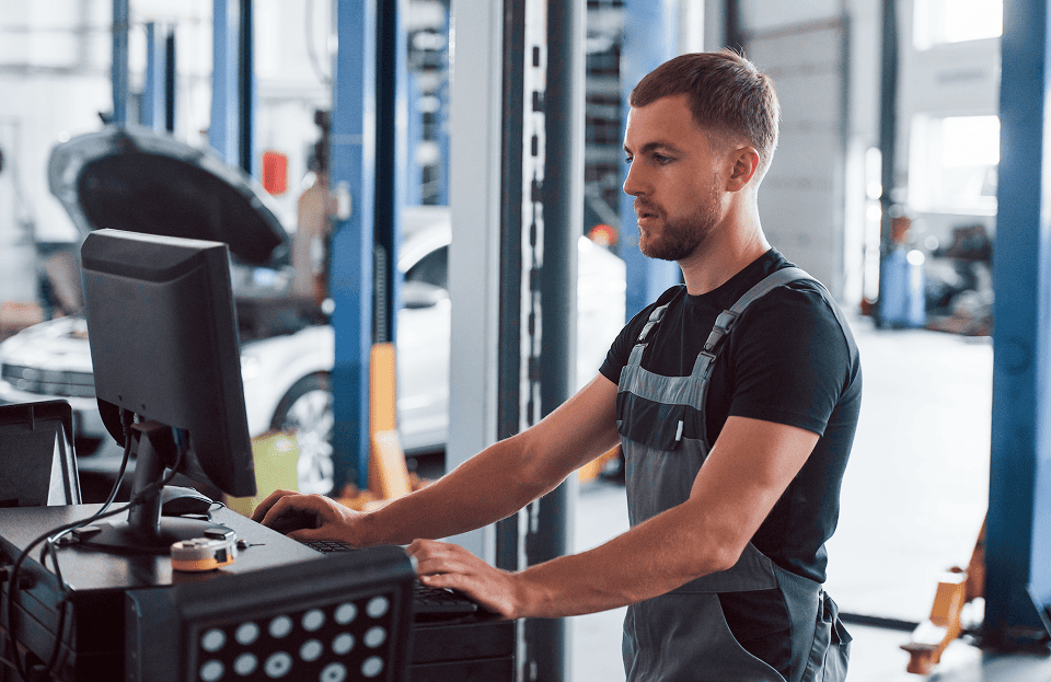 Technician working at computer in truck service bay